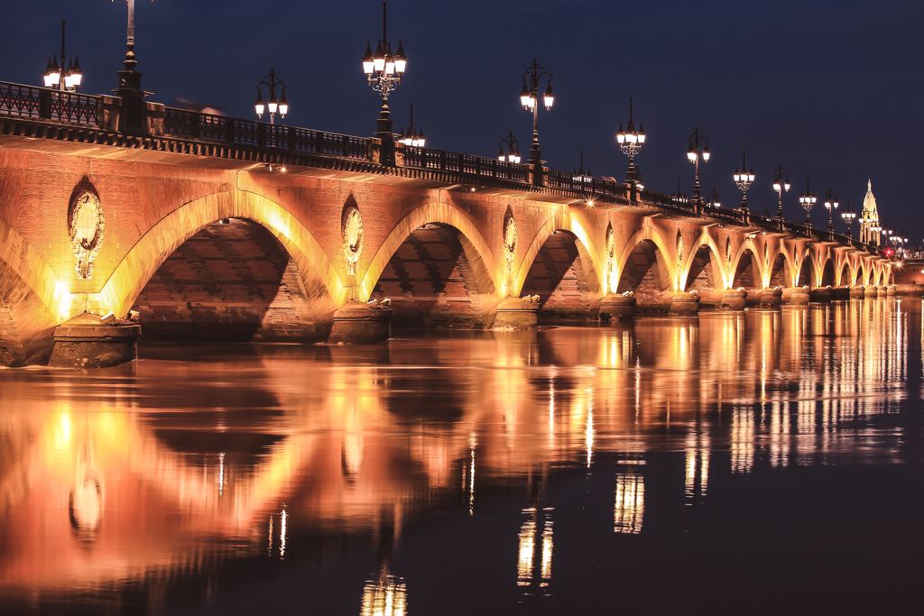The Pont de Pierre lit up at night over the Garonne in Bordeaux