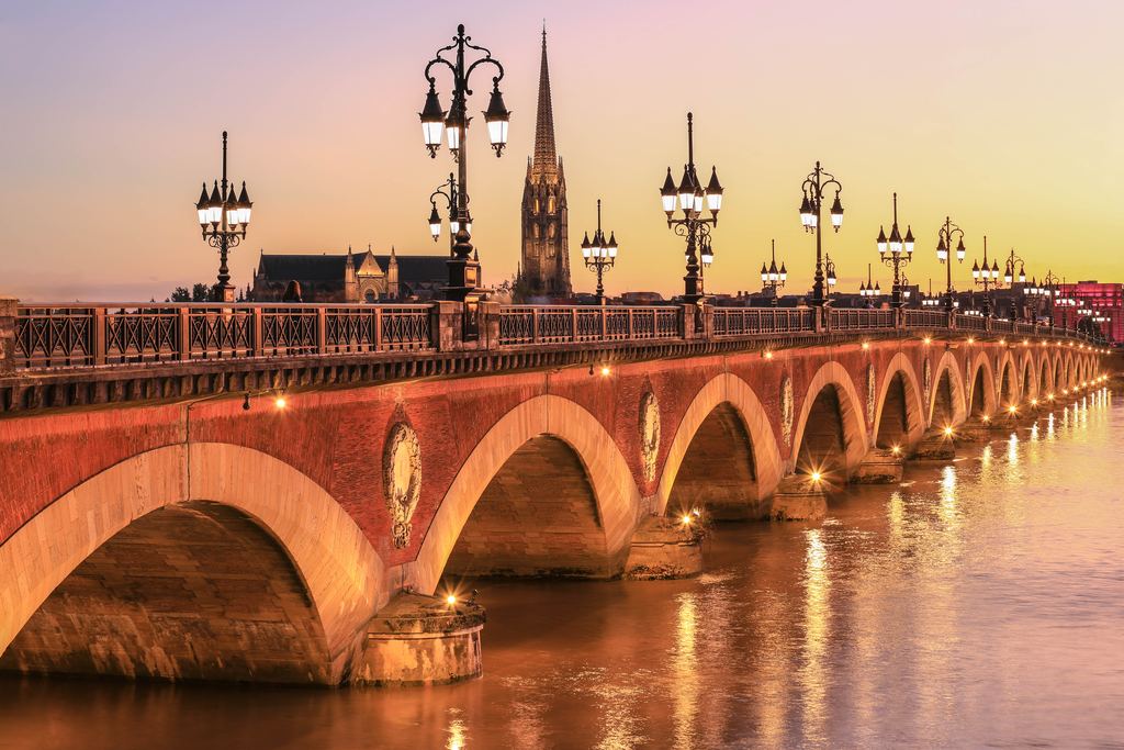 The Pont de Pierre and Saint-Michel church in Bordeaux at sunset