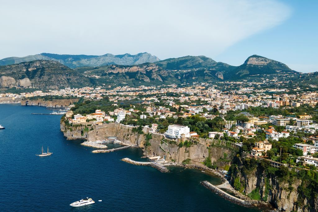 Aerial view of the Sorrento coast with cliffs, town and moored boats