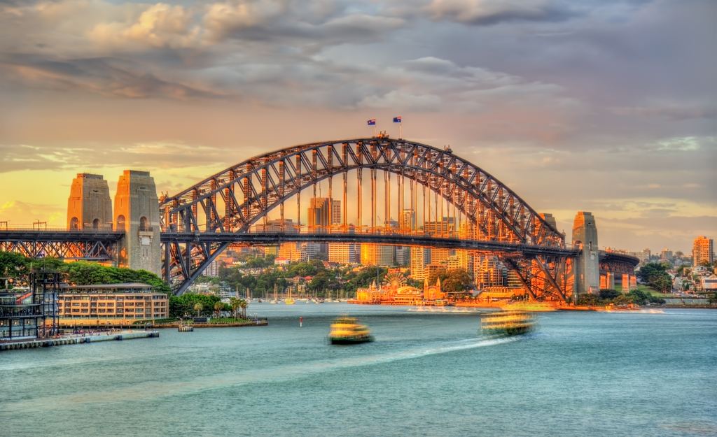 Sydney Harbour Bridge at sunset with ferries on the water, New South Wales