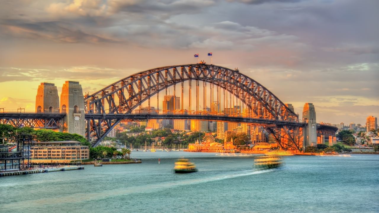 Sydney Harbour Bridge at sunset with ferries on the water, New South Wales