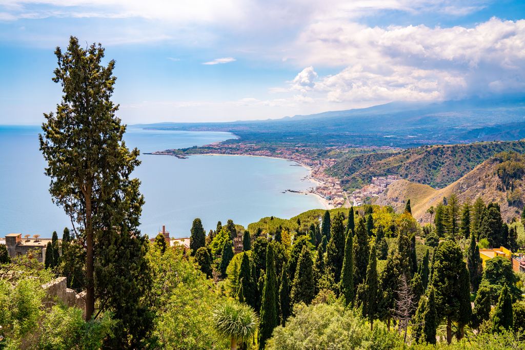 View over cypress trees to the bay and coast near Taormina
