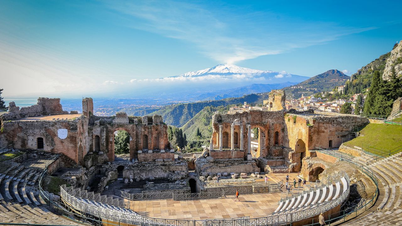 The Greek theatre of Taormina with snow-capped Mount Etna on the horizon