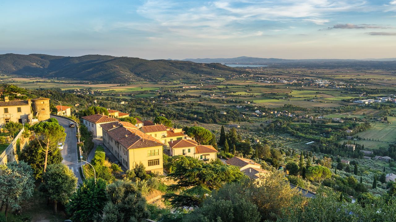 Tuscan hills and a hill town at sunset seen from Cortona, Arezzo province