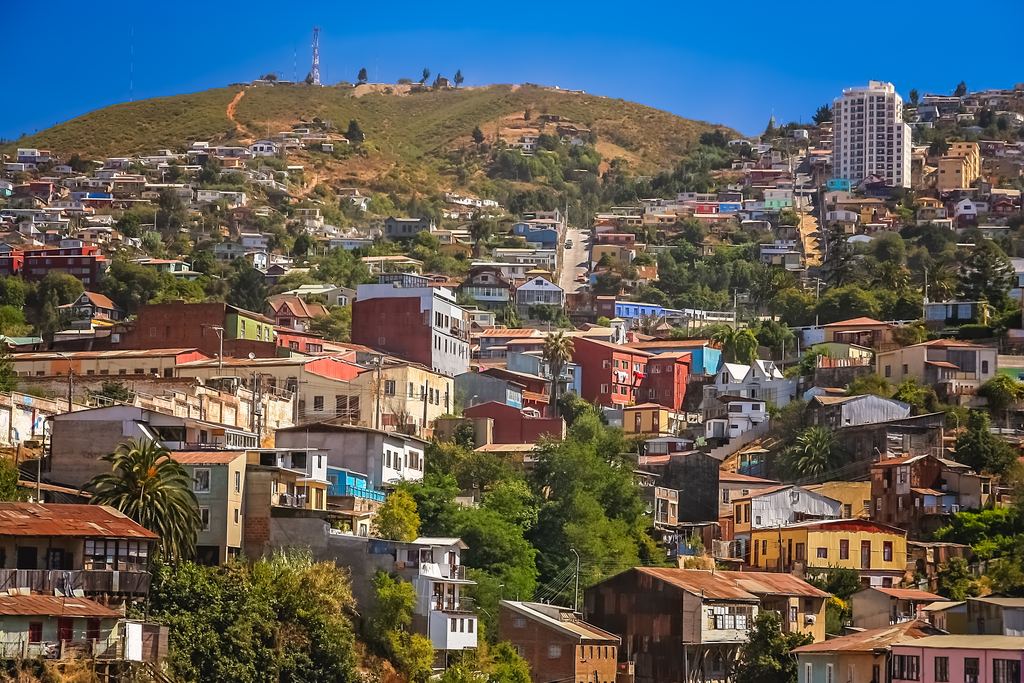 Houses stacked on a Valparaíso hill under a blue sky