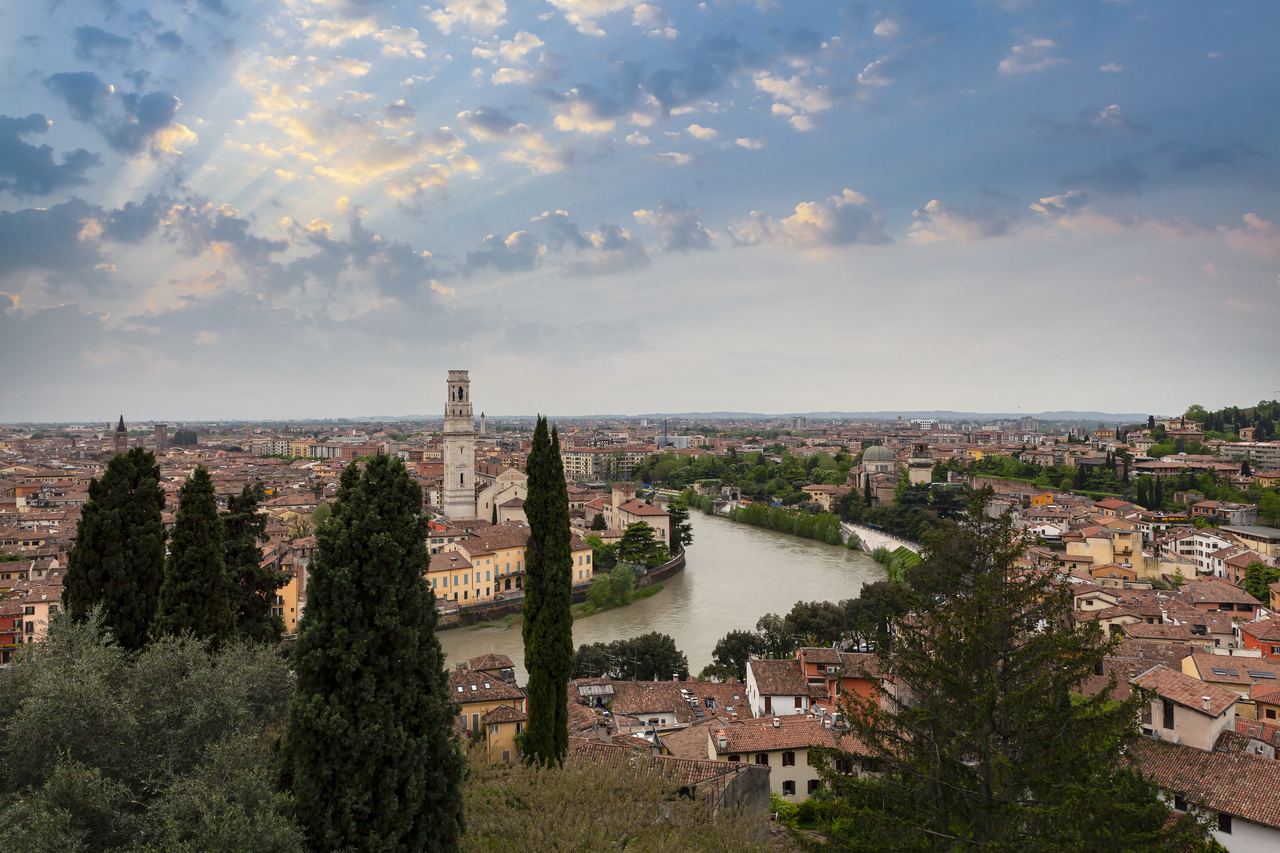 View over the rooftops of Verona and the bend of the Adige river at sunset